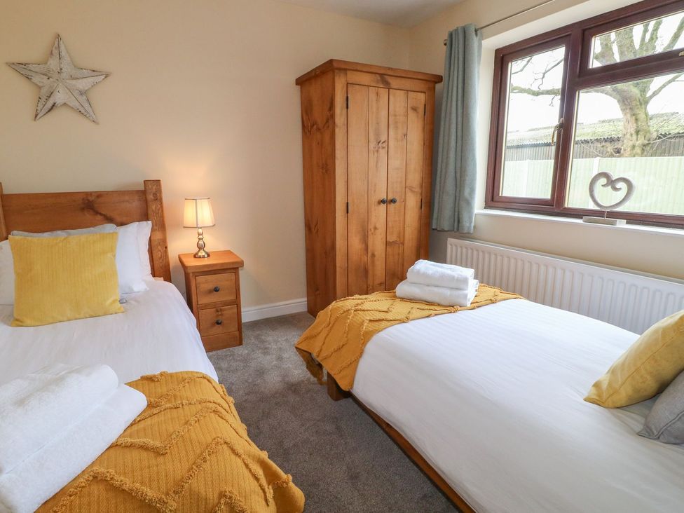 A bedroom with two beds and a wardrobe at The Lodge in Wirksworth
