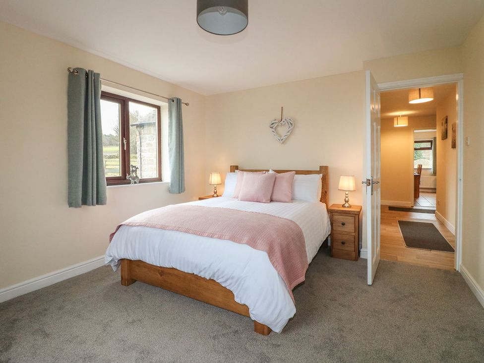 A bedroom with a bed and nightstand at The Lodge in Wirksworth