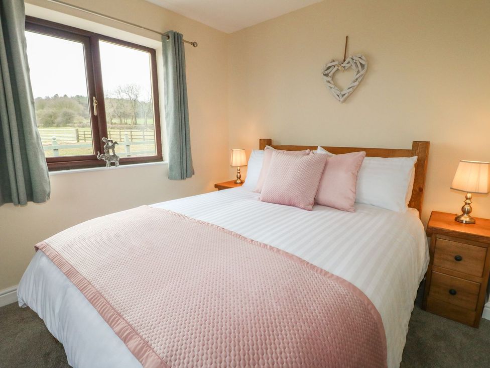 A bedroom with a bed and window at The Lodge in Wirksworth
