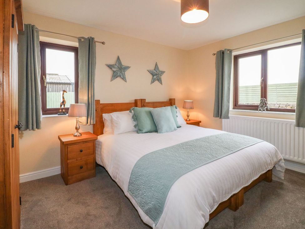 A bedroom with a bed and bedside table at The Lodge in Wirksworth