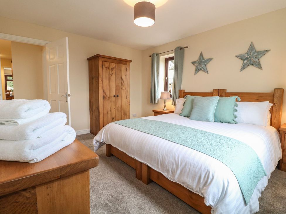 A bedroom with a bed and wardrobe at The Lodge in Wirksworth
