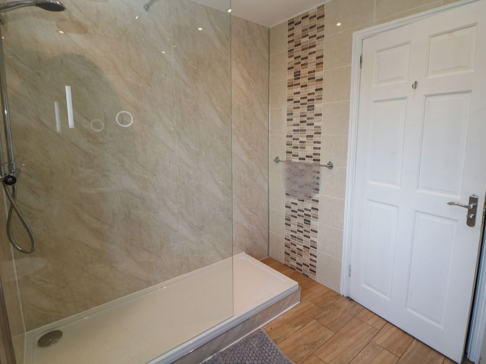 A bathroom with a shower and towel rail at The Lodge in Wirksworth