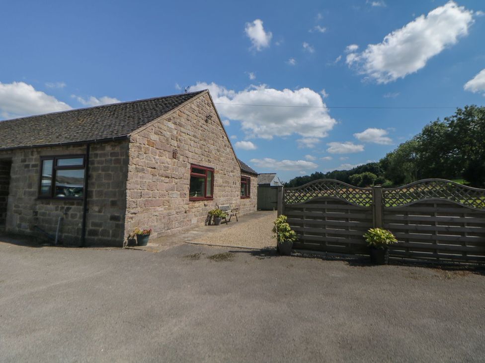 An outdoor view of a stone cottage with a gate and plants at The Lodge in Wirksworth