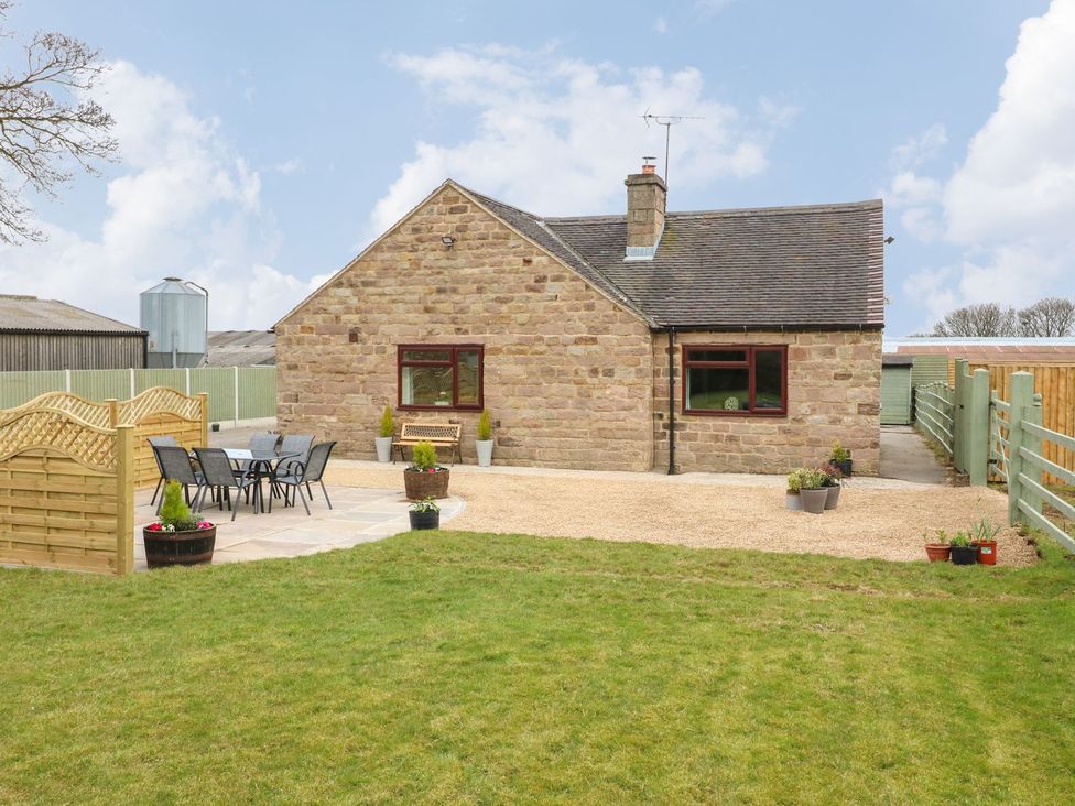 A stone house with a garden and outdoor seating area at The Lodge in Wirksworth
