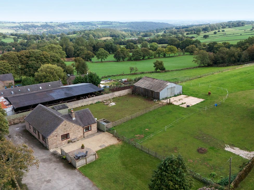 An aerial view of a farmhouse and barn with fields at The Lodge in Wirksworth