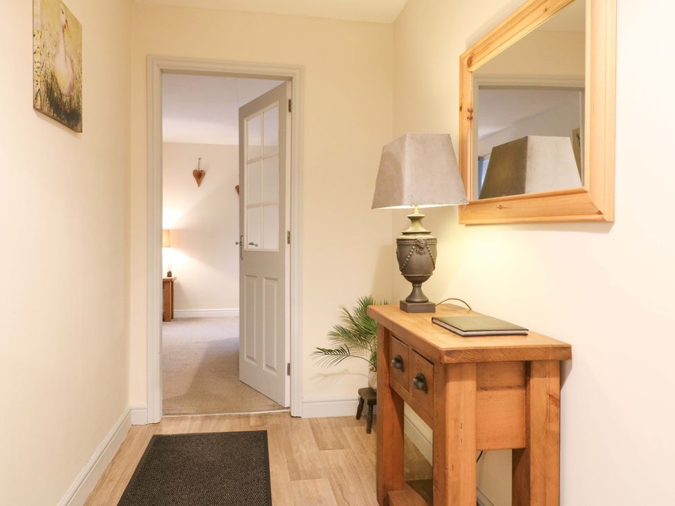 A hallway with a table and lamp at The Lodge in Wirksworth