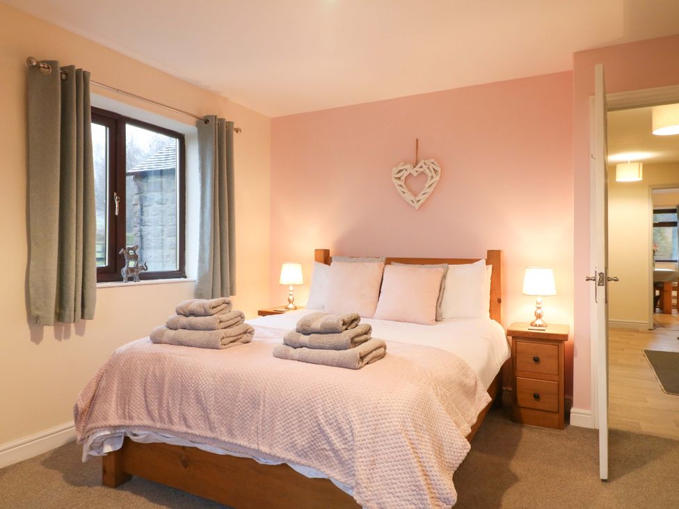 A bedroom with a bed and nightstand at The Lodge in Wirksworth