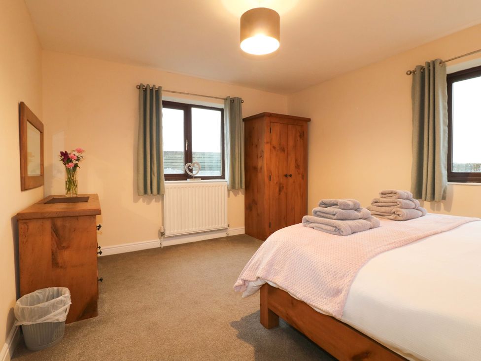 A bedroom with a bed, dresser, and wardrobe at The Lodge in Wirksworth