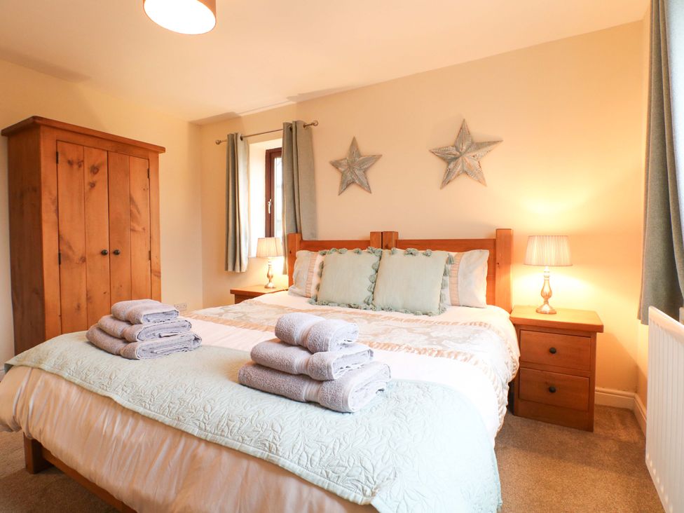 A bedroom with a bed and wardrobe at The Lodge in Wirksworth