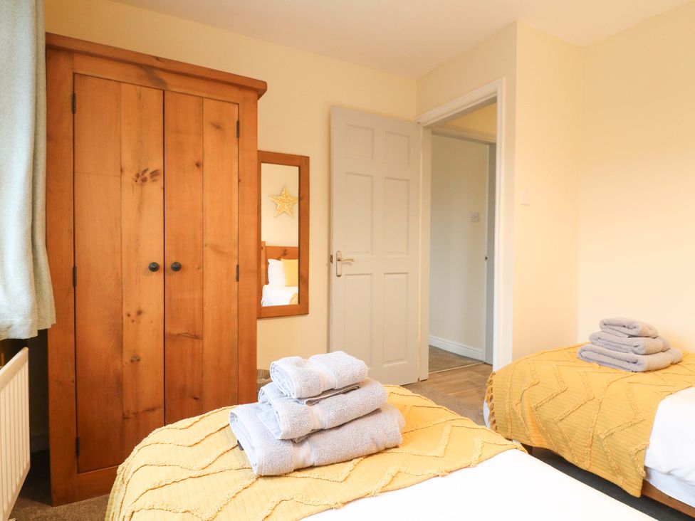 A bedroom with a wardrobe and two beds at The Lodge in Wirksworth