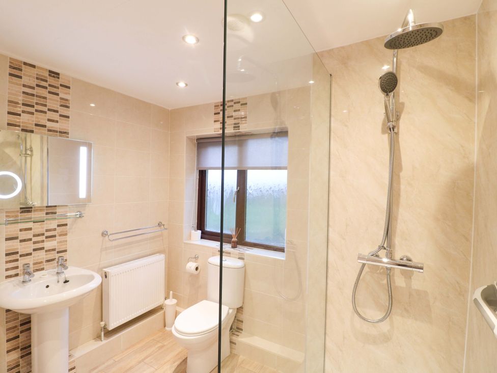 A bathroom with a shower, sink and toilet at The Lodge in Wirksworth
