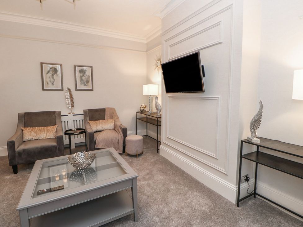 A living room with armchairs and a television at 16 Seafield Terrace South Shields