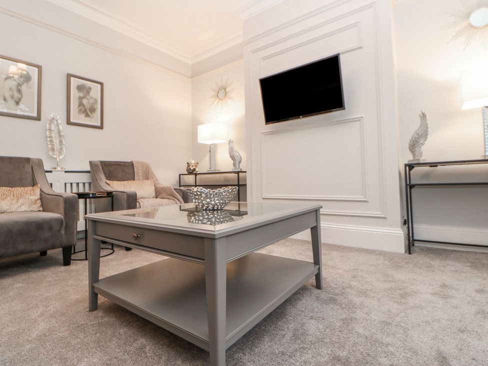 A living room with armchairs and a coffee table at 16 Seafield Terrace South Shields