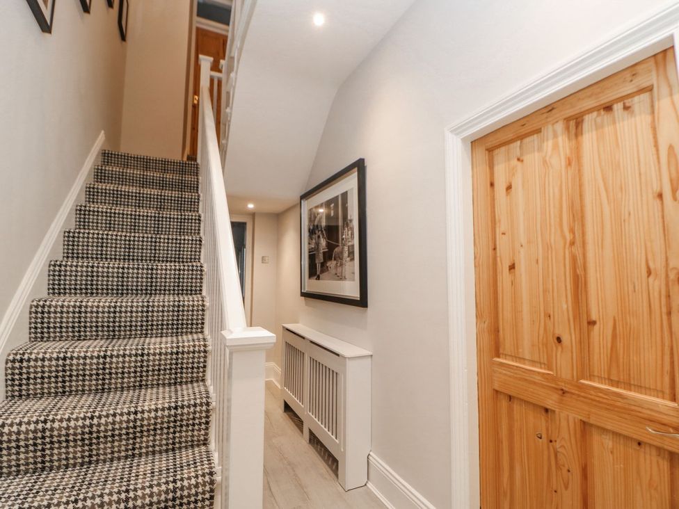 A hallway with stairs and a wooden door at 16 Seafield Terrace South Shields