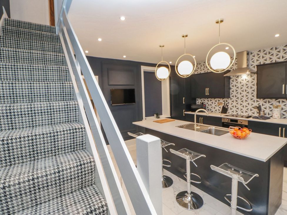 A kitchen with a kitchen island and stools at 16 Seafield Terrace South Shields