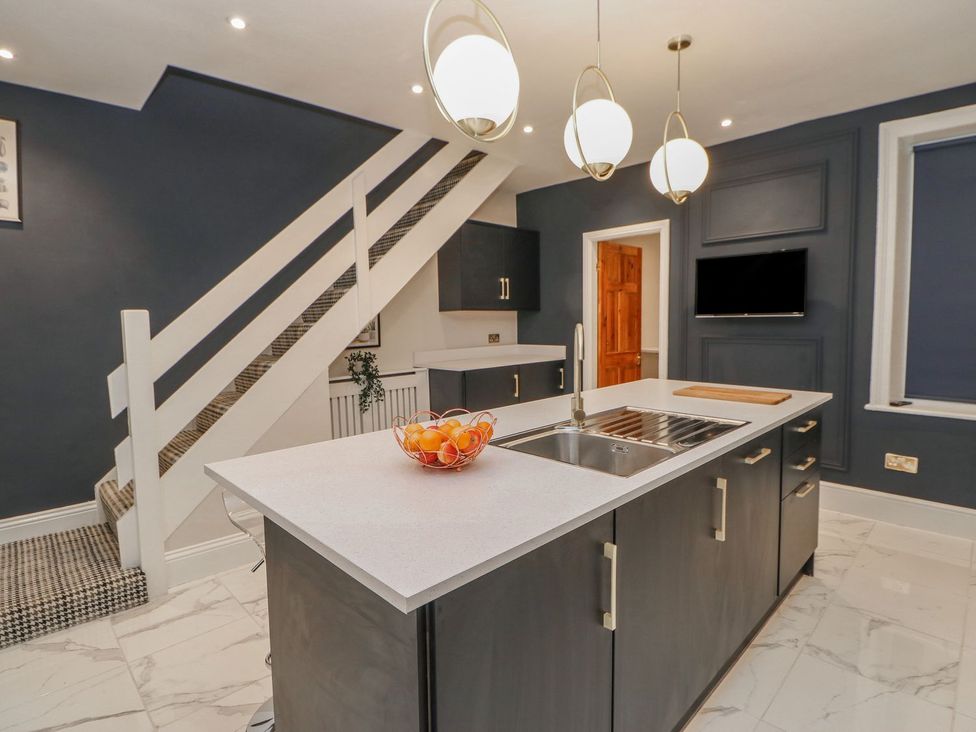 A kitchen with an island and staircase at 16 Seafield Terrace South Shields