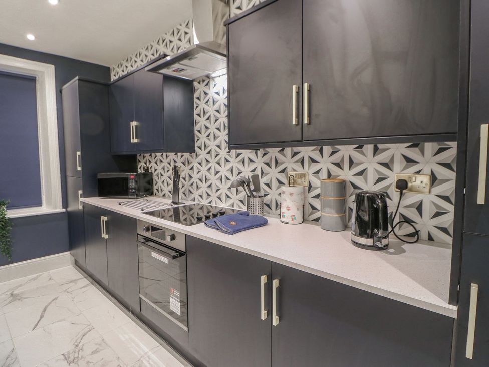A kitchen with cabinets, stove, sink, and appliances at 16 Seafield Terrace South Shields
