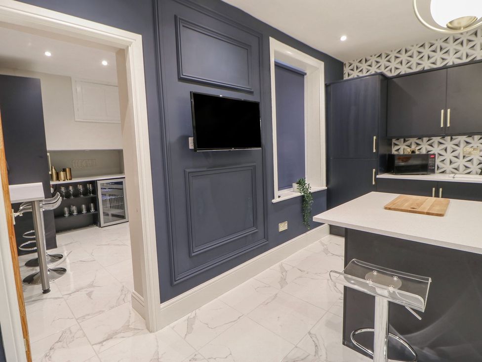 A kitchen with a countertop, cabinets, and a television at 16 Seafield Terrace, South Shields