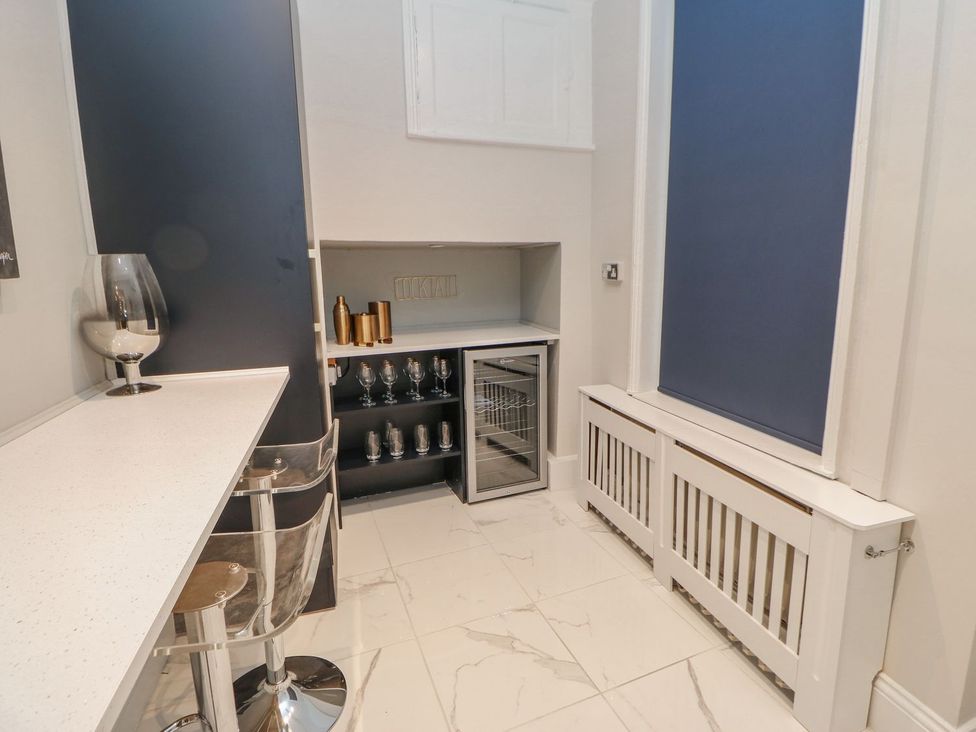 A bar area with a wine cooler and bar stools at 16 Seafield Terrace South Shields