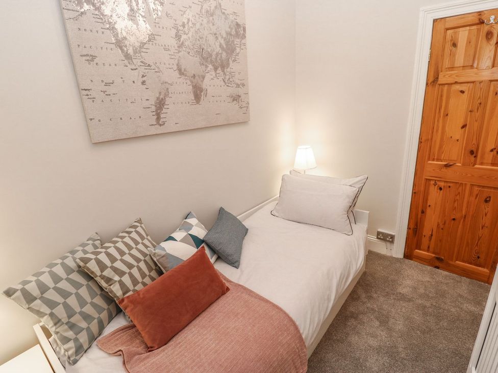 A bedroom with a bed and map art on the wall at 16 Seafield Terrace in South Shields