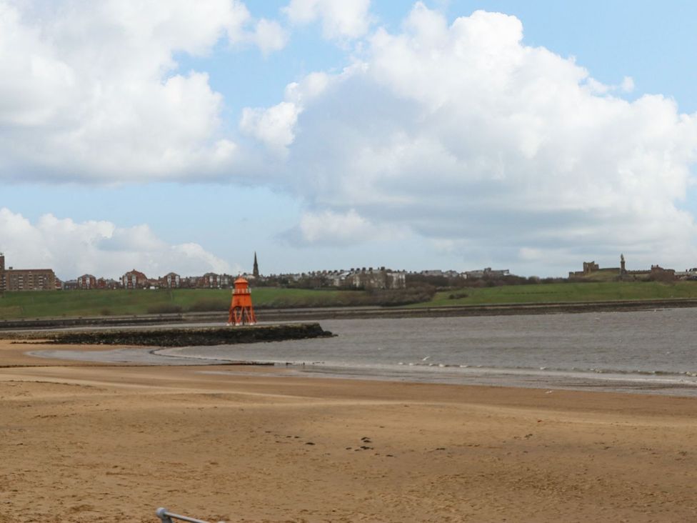 A beach with a lighthouse and buildings in the background at 16 Seafield Terrace South Shields