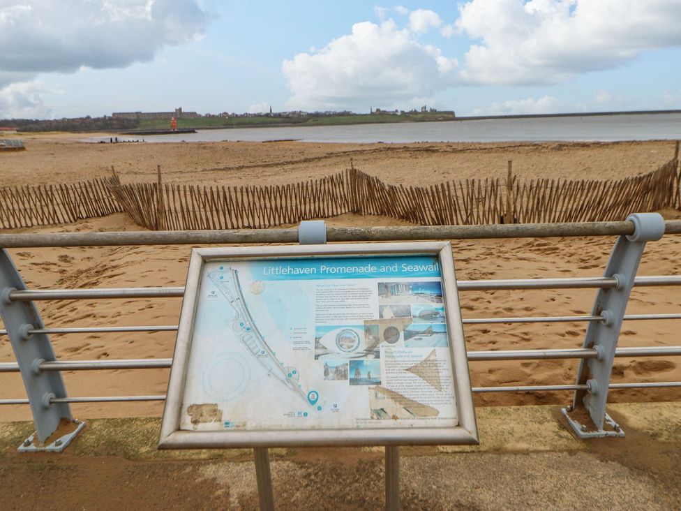 A beach view with a sign at Littlehaven Promenade and Seawall in South Shields