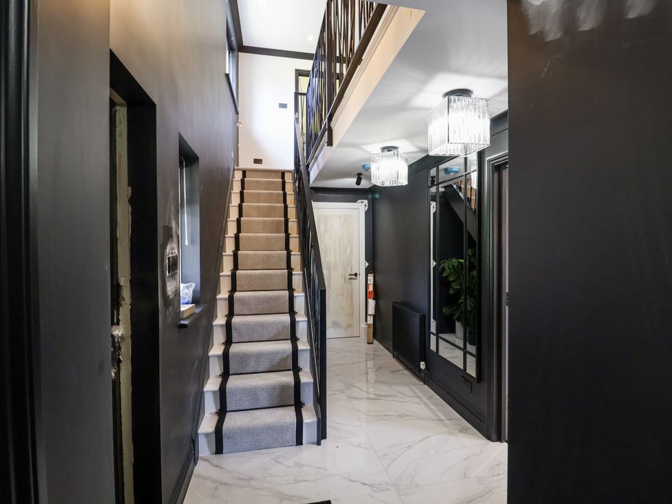 A hallway with stairs and light fixtures at Holly Farm near Brantham