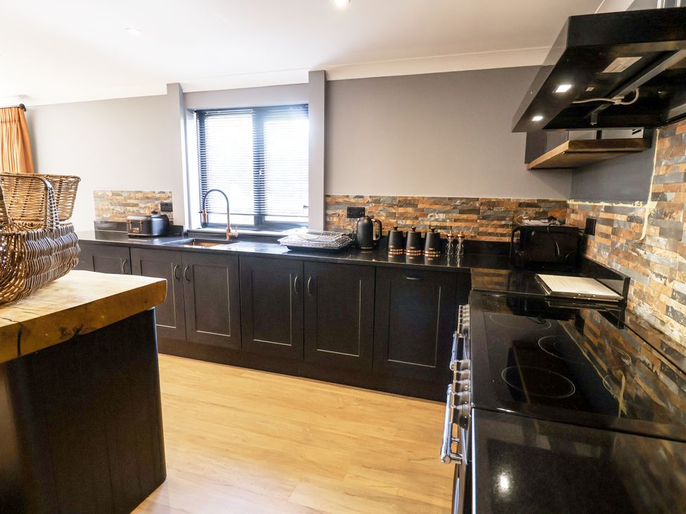 A kitchen featuring a stove, sink, and countertop at Holly Farm near Brantham