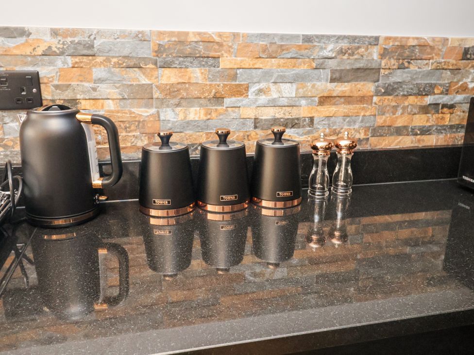 A kitchen countertop with a kettle and storage containers at Holly Farm near Brantham