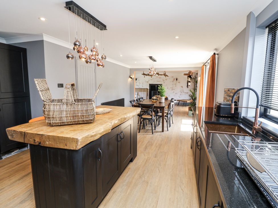 A kitchen with a wooden island and dining area at Holly Farm near Brantham
