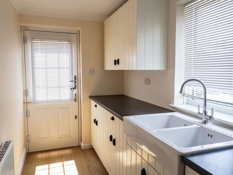 A kitchen with a sink and cabinets at Holly Farm near Brantham