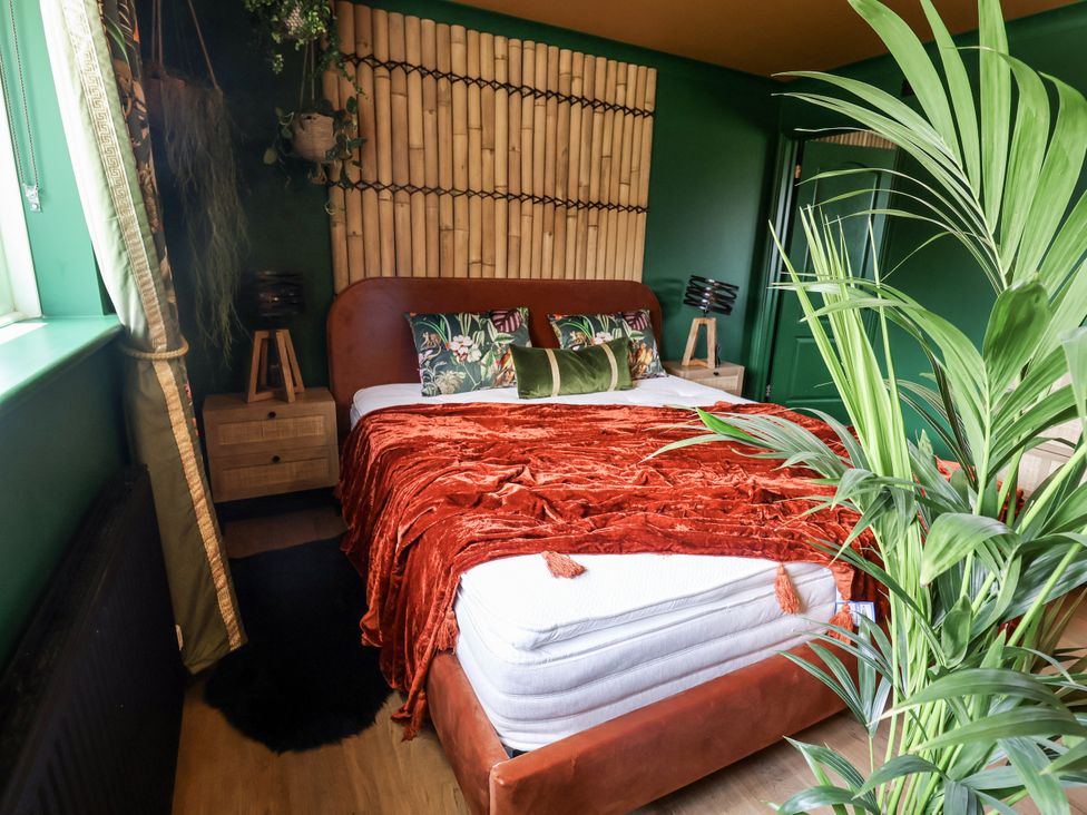 A bedroom with a bed and decorative pillows at Holly Farm near Brantham