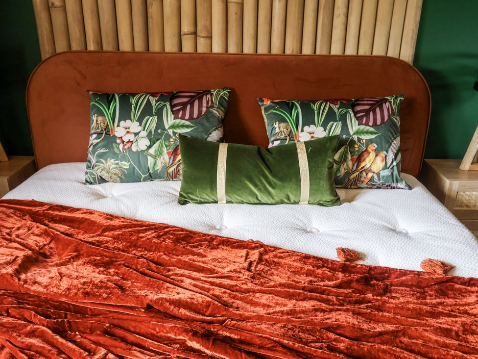 A bed with decorative pillows and a blanket at Holly Farm and Annexe near Brantham