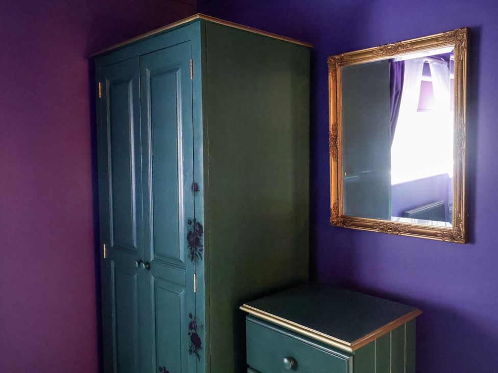 A bedroom with a wardrobe and a mirror at Holly Farm near Brantham