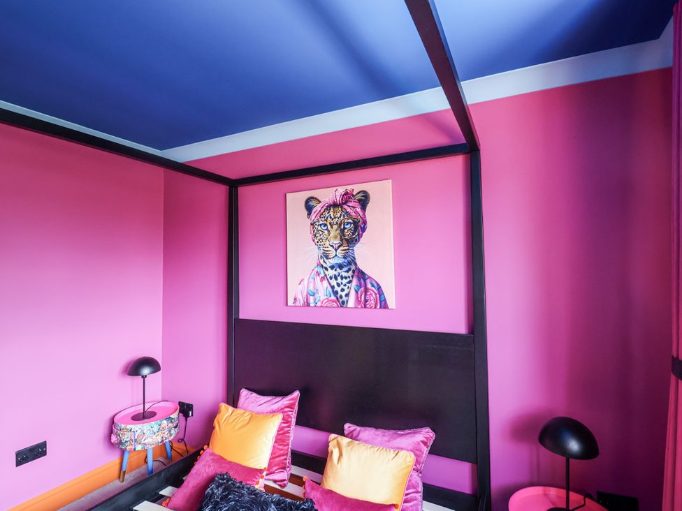 A bedroom with a bed and colorful cushions at Holly Farm near Brantham