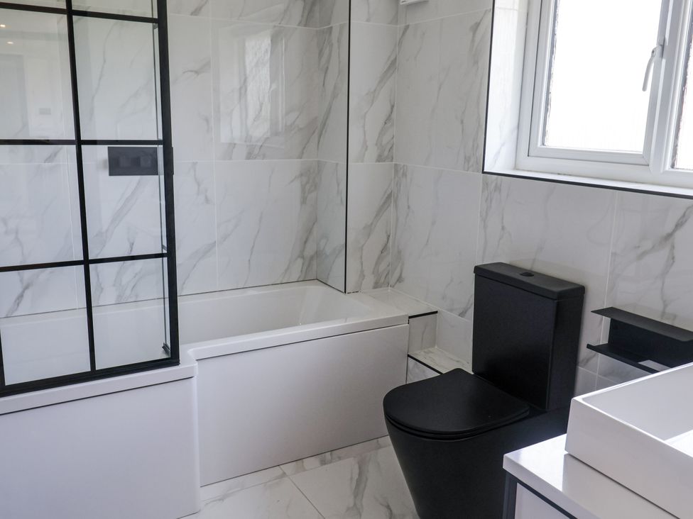 A bathroom with a bathtub and toilet at Holly Farm near Brantham