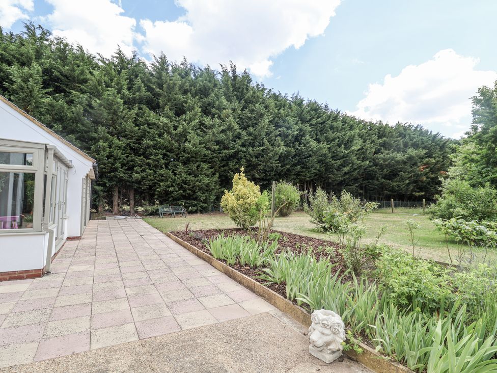 A garden with patio and trees at Holly Farm near Brantham