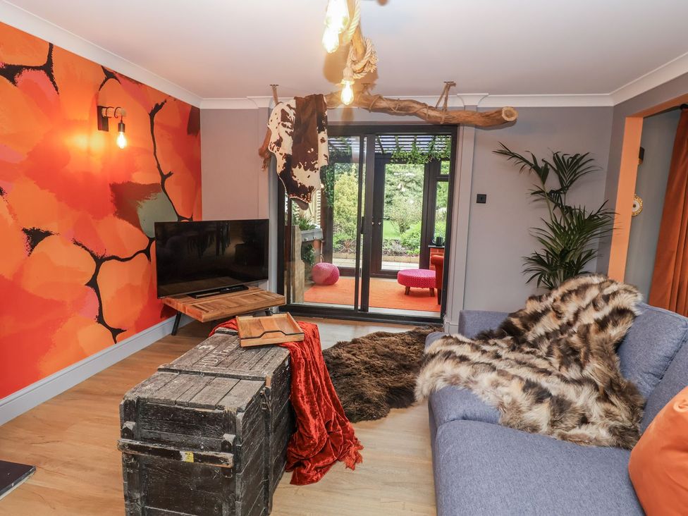 A living room with a television and sofa at Holly Farm near Brantham