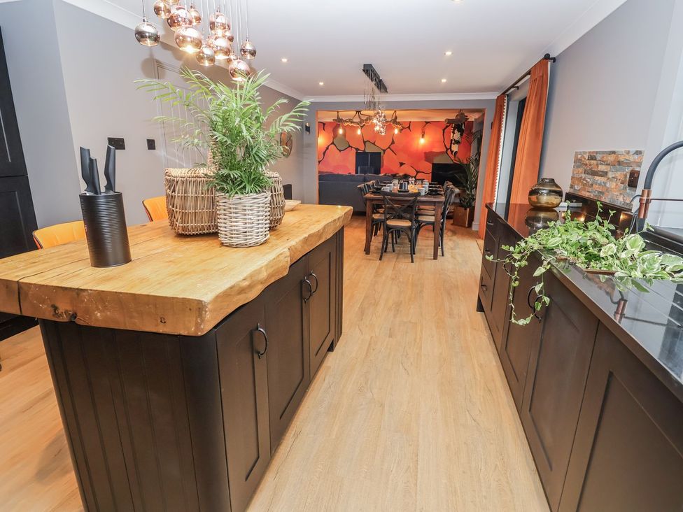 A kitchen with a wooden island and dining area at Holly Farm near Brantham