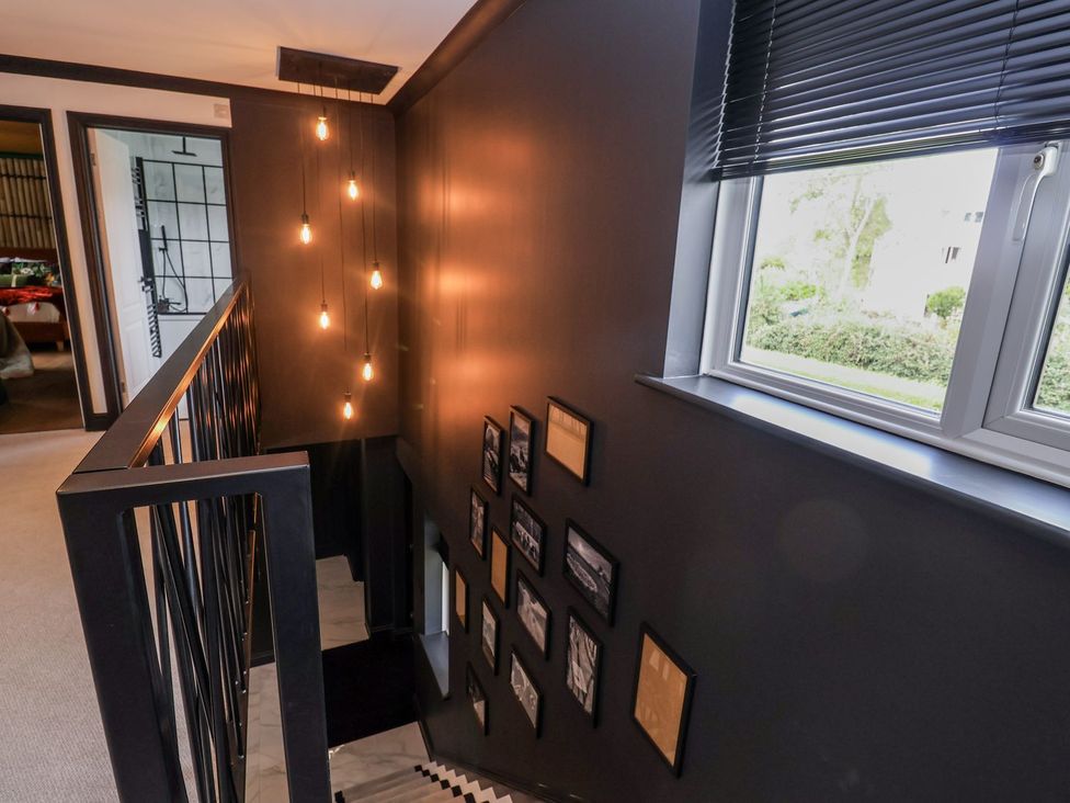 A staircase with light fixtures and photo frames at Holly Farm near Brantham