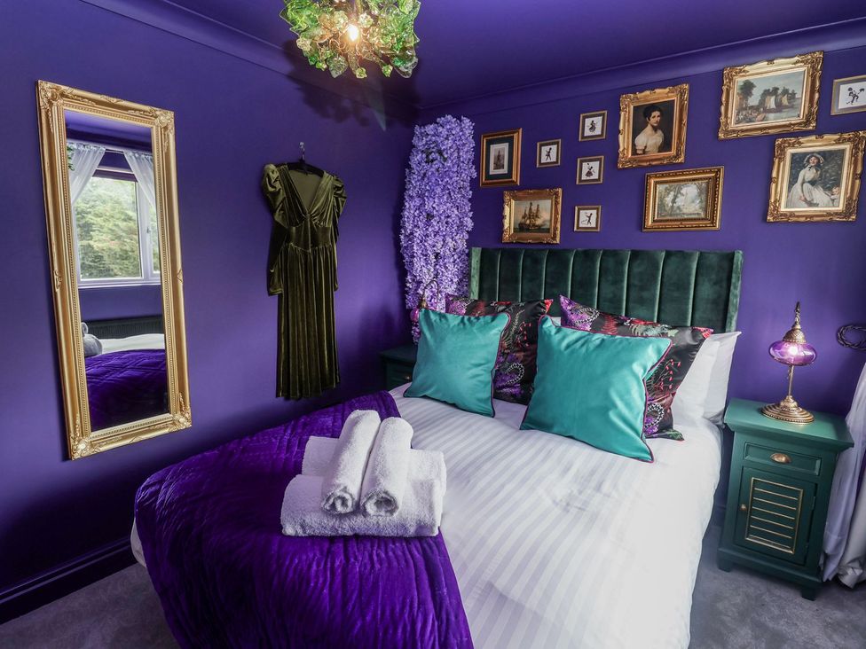 A bedroom with a bed and artwork on the wall at Holly Farm near Brantham