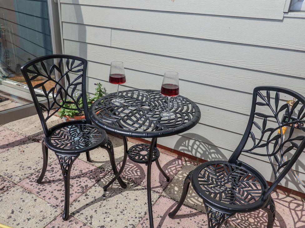 A table and two chairs with glasses on a patio at Holly Farm near Brantham