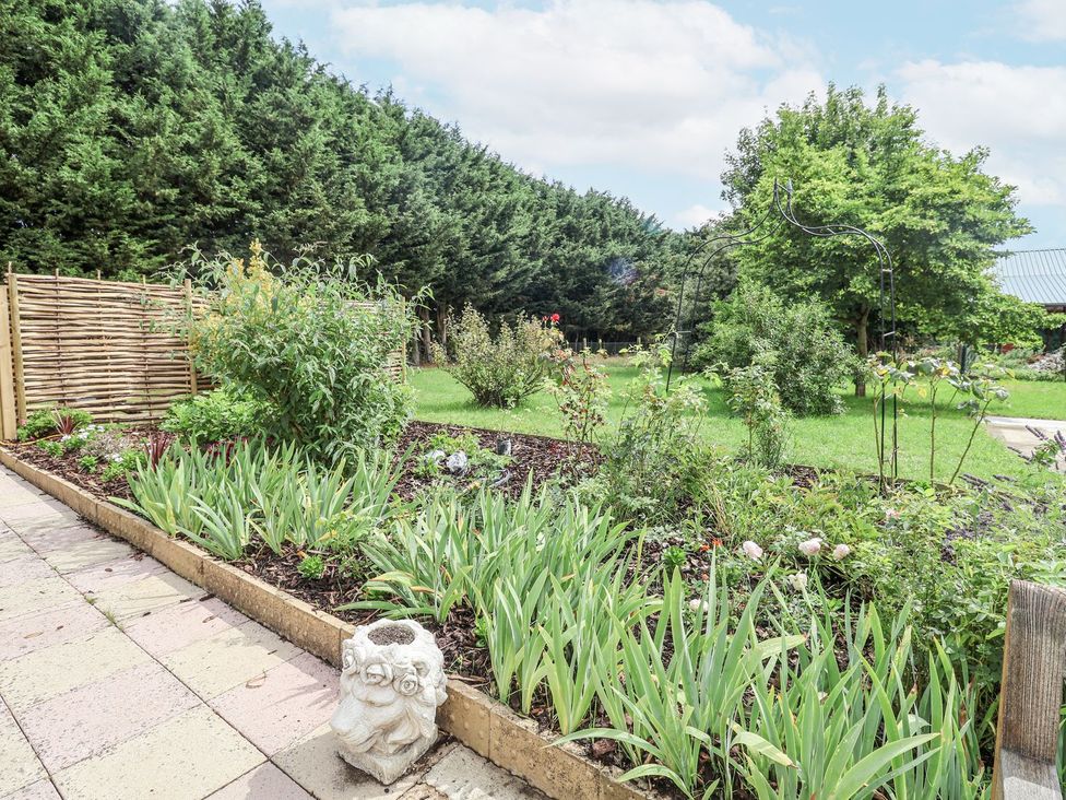 A garden with flowers and a decorative sculpture at Holly Farm near Brantham
