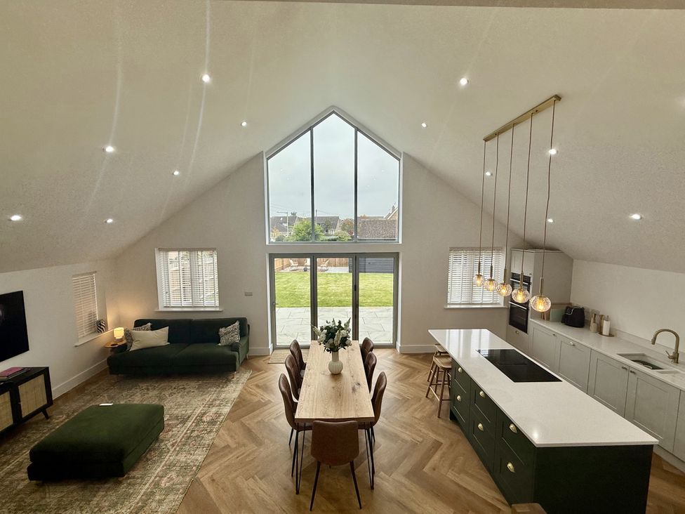 A living room with a sofa, dining table and kitchen island at Bader House in Ipswich