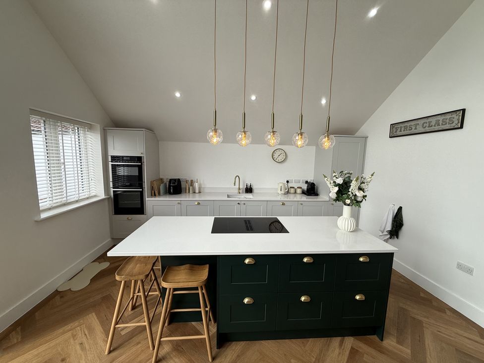 A kitchen with an island and stools at Bader House in Ipswich