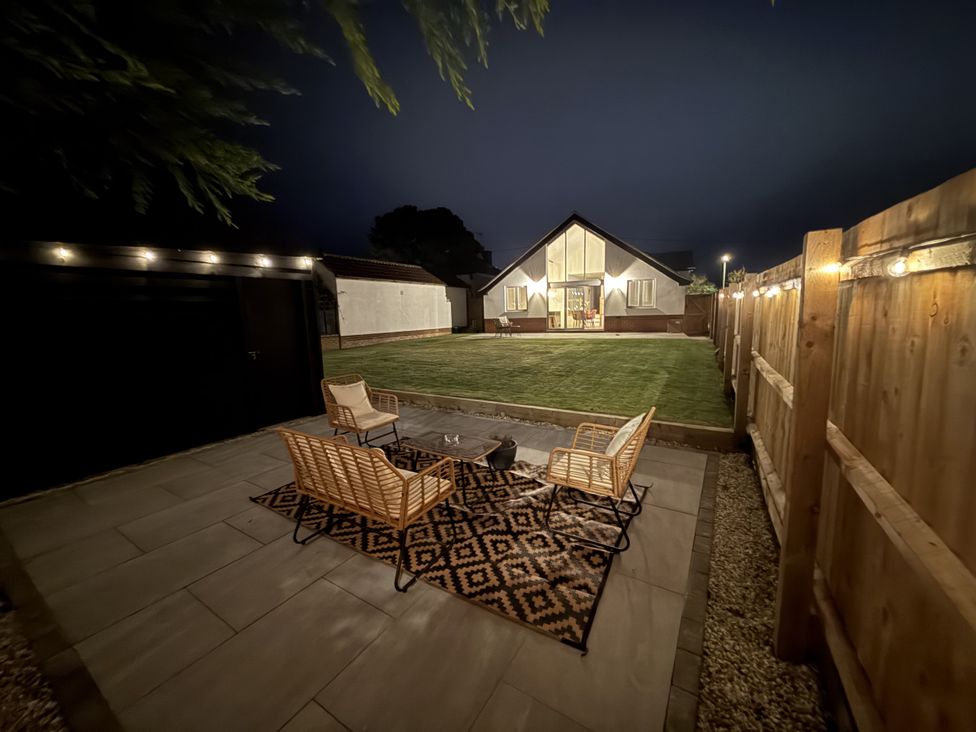 A garden with seating area and house at Bader House in Ipswich