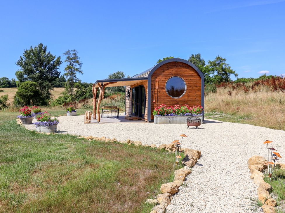 A house with a gravel path and flower pots at Bugley Pools Hideaway in Bugley near Gillingham