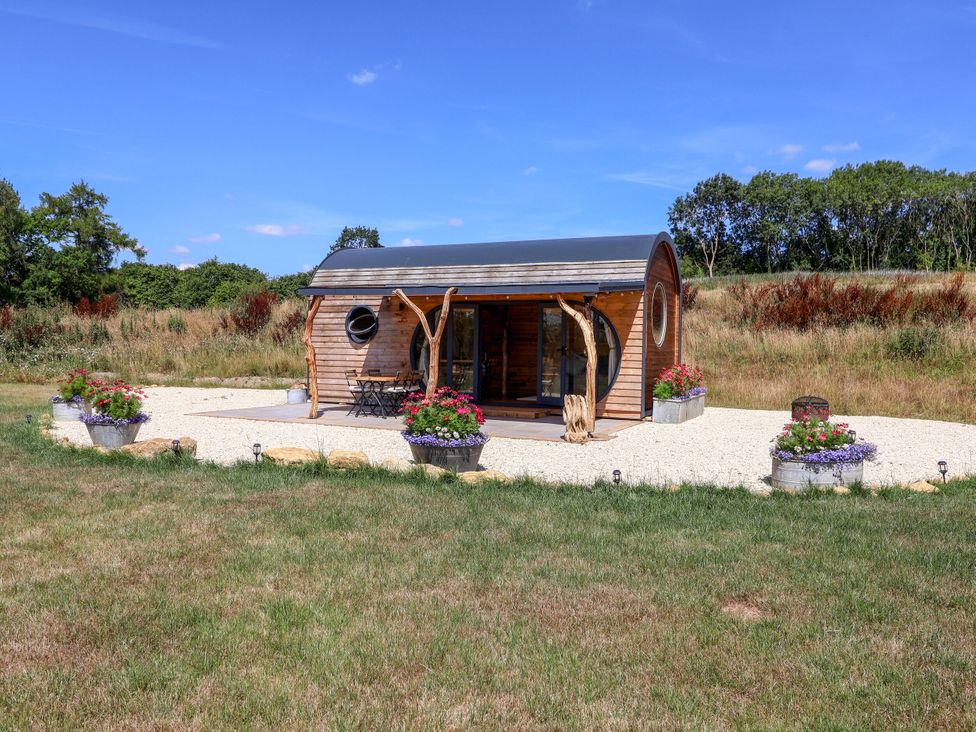 A cabin with outdoor seating and planters at Bugley Pools Hideaway Bugley near Gillingham
