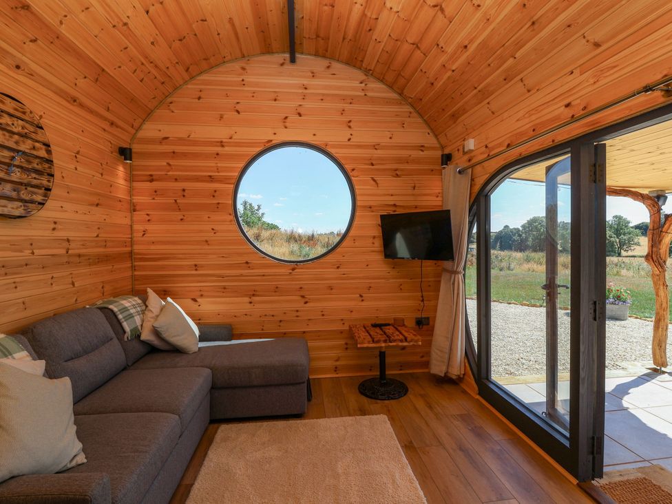 A living room with a couch and window at Bugley Pools Hideaway in Bugley near Gillingham