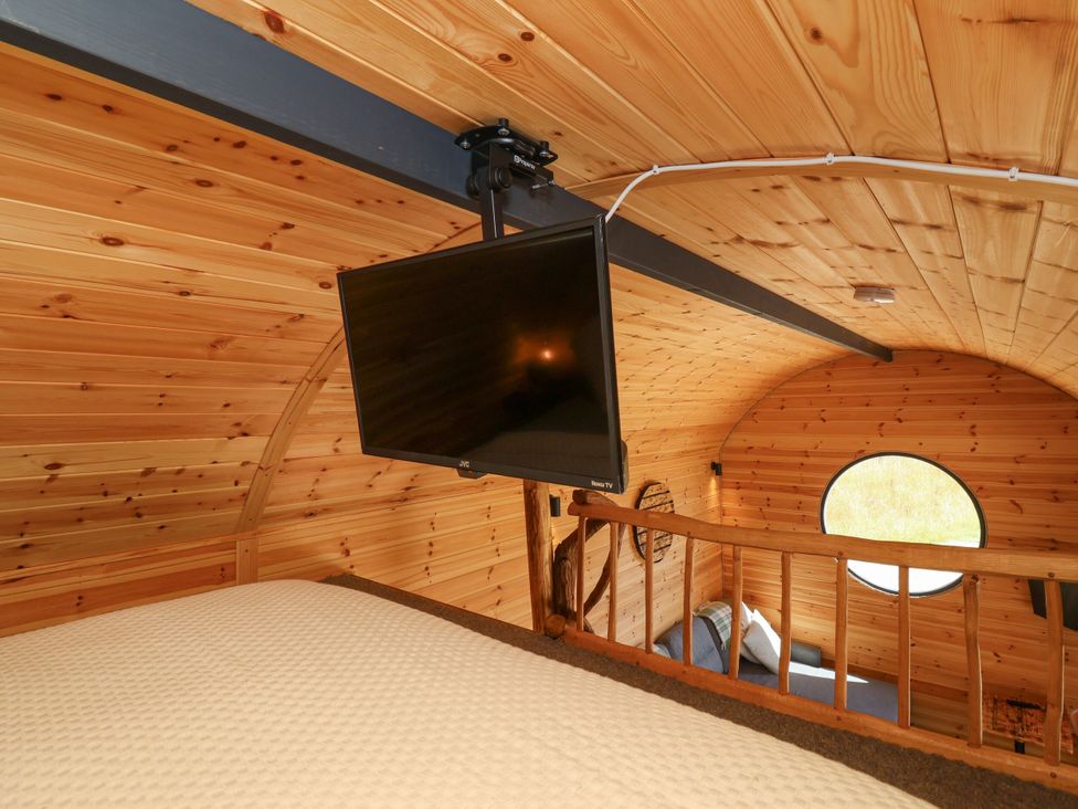 A bedroom with a television mounted on the wall and a bed at Bugley Pools Hideaway in Bugley near Gillingham